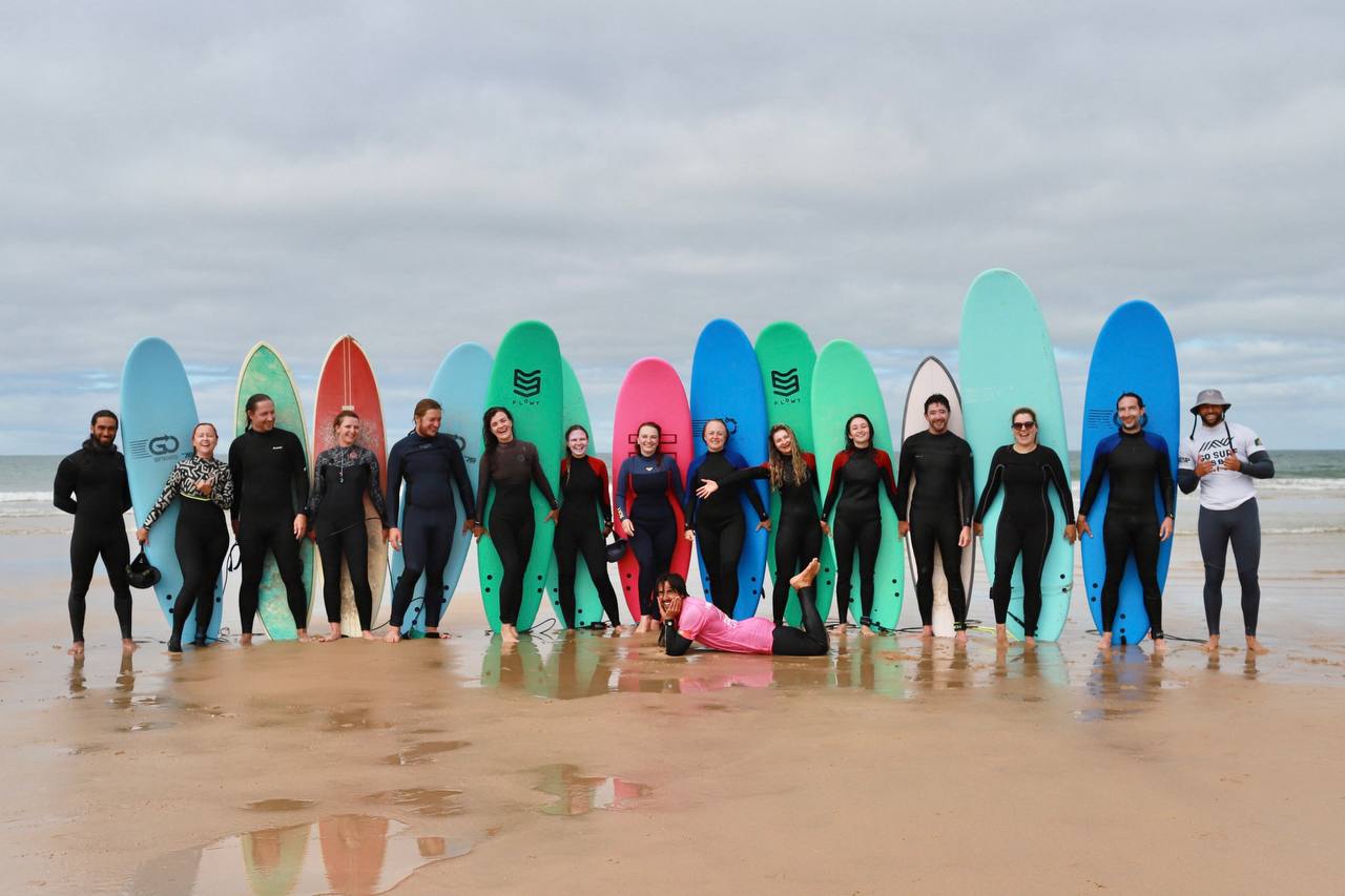 The surfing group together with their colourful boards on the beach