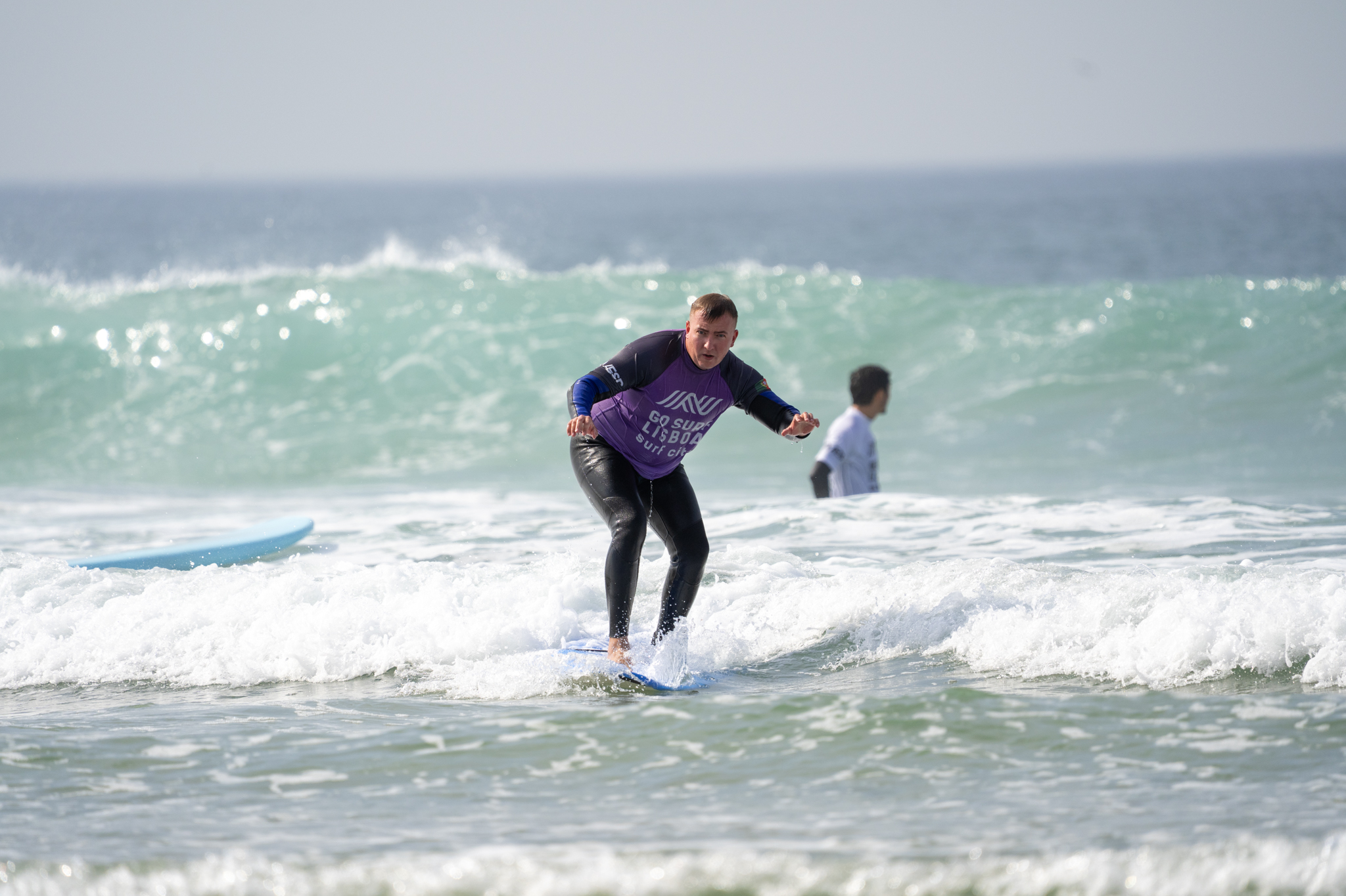 A participant riding a wave with Go Surf Lisboa